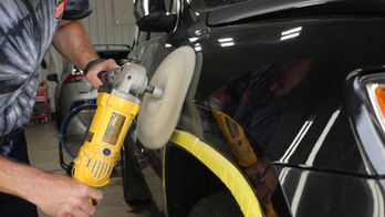 Employee of Phoenix Collision of Springfield, Illinois buffing and polishing scratches out of a vehicle with minor damage.