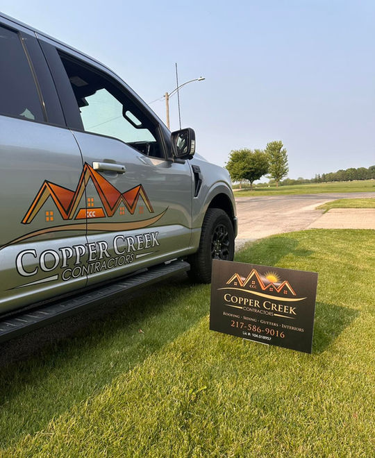 Copper Creek Contractors of Champaign, Illinois roofing trucks with branded logos.