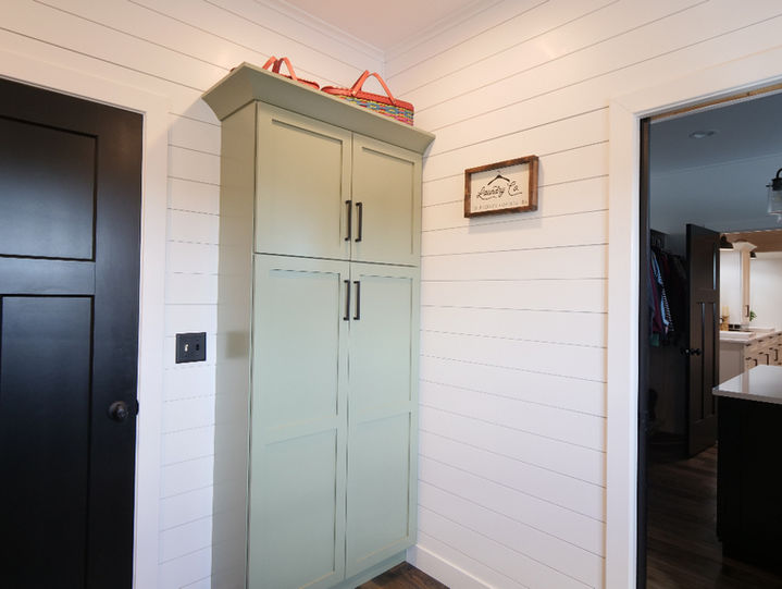 Green cabinet for a laundry room corner. Space designed by Capitol Kitchen and Bath in Springfield, Illinois. 