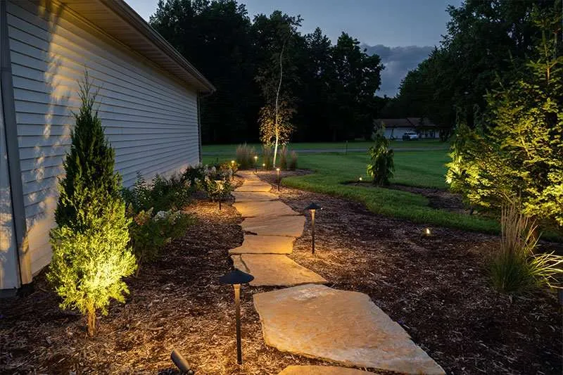 A paA stone pathway at night built in a residential backyard by Knob Hill Landscaping Company in Springfield, Illinois. 