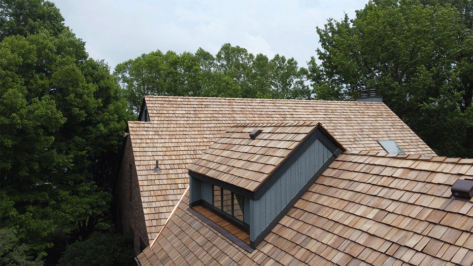 Aerial side view of a new roof with wooden shingles completed by Copper Creek Contractors of Central Illinois.