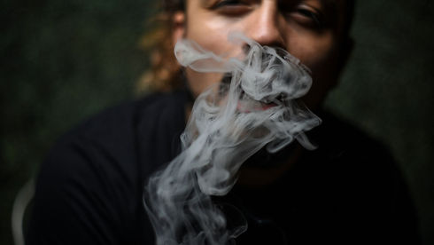 Man blowing his smoke into the camera.