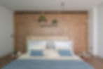 Bedroom with an oak-panelled wall and blue cushions