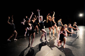 KDF musical theatre dancers in black costumes posing on stage