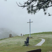 Camino con una cruz y peregrinos a la distancia