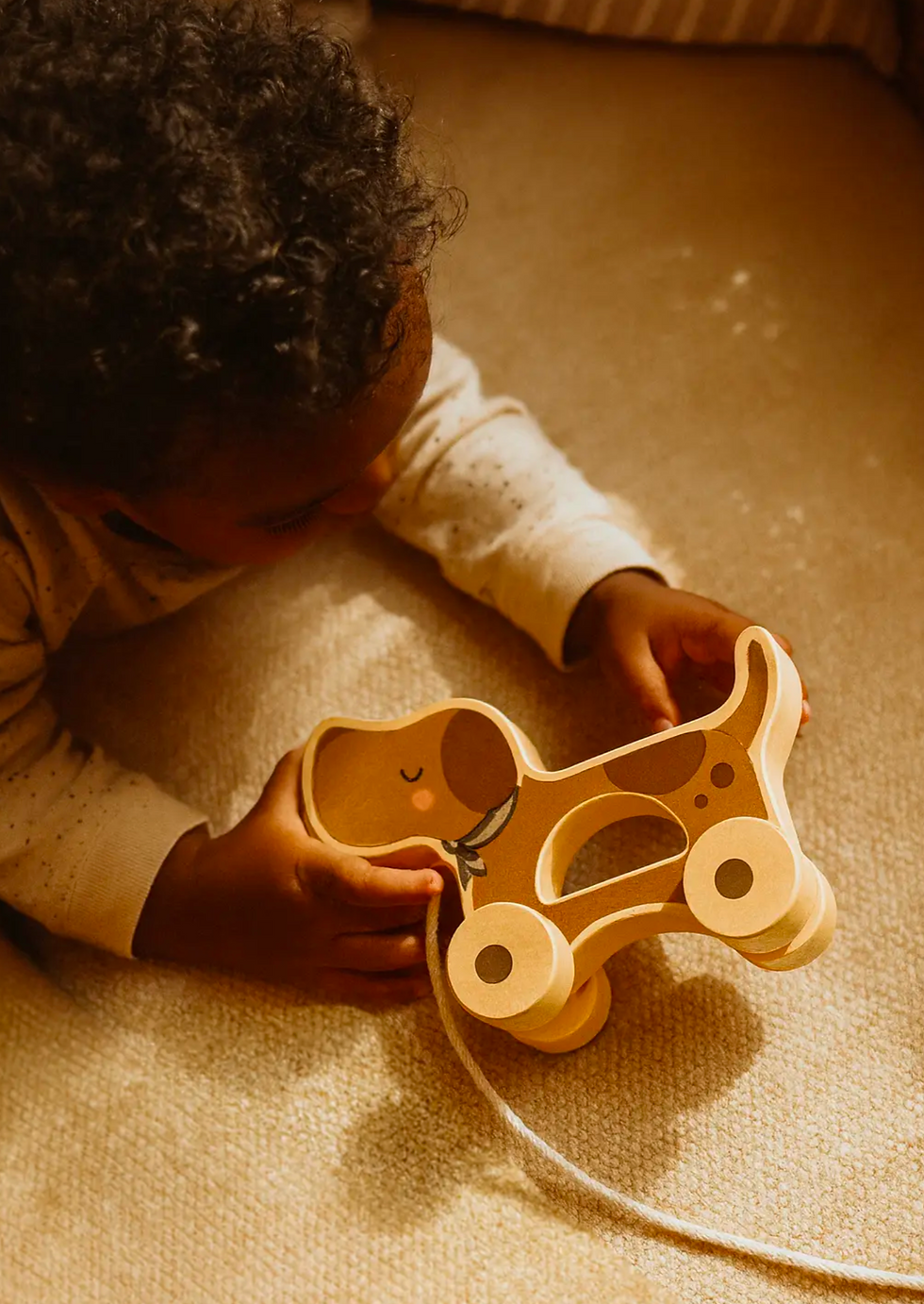 Child playing with wooden puppy pull along toy