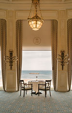 Une table dressée pour deux personnes devant des baies vitrées donnant sur la mer. Cet espace emblématique de La Rotonde est conçu pour des conversations confidentielles entre dirigeants et décideurs de l'IA lors du dîner VIP AI ON US en octobre 2025.