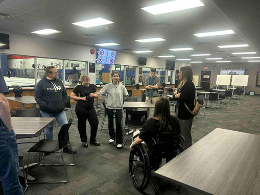 Brook Aleksic and her mom smiling at a live event with a large screen in the background.
