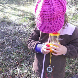 child outdoors with bug catcher