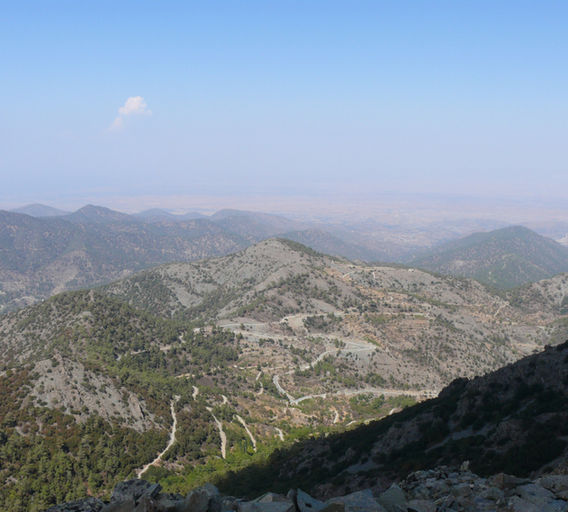 Vista towards the north from Madari peak, Troodos. Different peaks are seen, under blue skies and Mesaoria plain in the background.