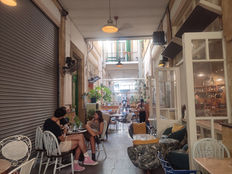 An arcade in Walled Nicosia. People sitting, relaxing, drinking coffee. Not very bright, because of shade.