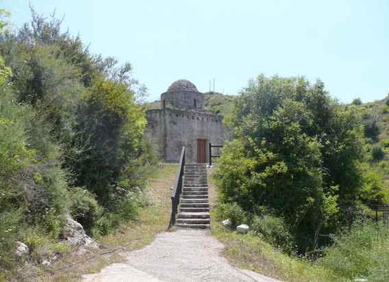 Tiny medieval domed stone-built Ayia Paraskevi chapel, near Kato Akourdalia and Kritou Terra villages. Tall bushes on the two sides of a staircase leading to the church.