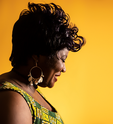 Woman in profile smiling against a yellow background.