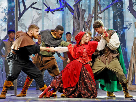 Dramatic stage scene with actors in forest costumes
