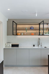 Modern kitchen with grey cabinets and illuminated glass shelves