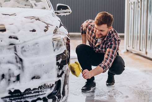 young-man-washing-his-car-carwash.jpg