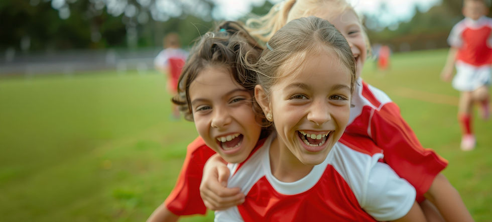 Two smiling girls in red sports jerseys