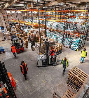 Busy logistics warehouse with forklifts and staff