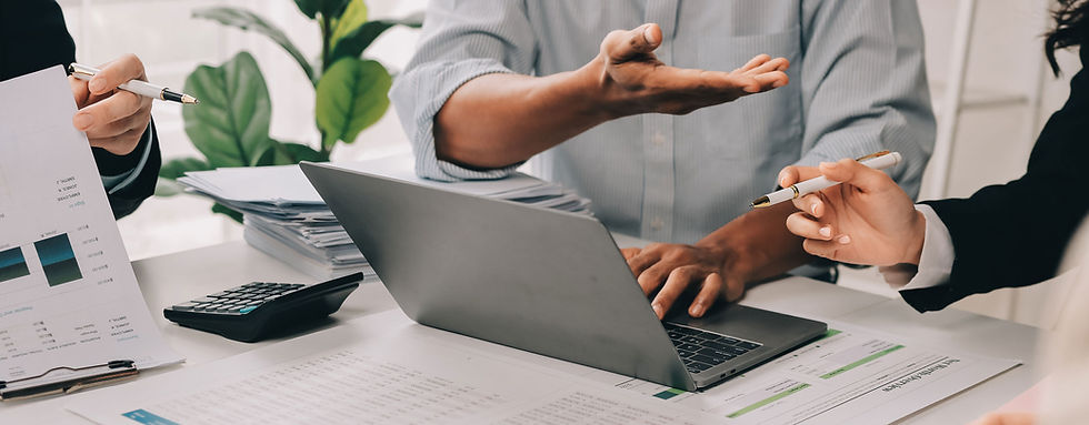 Business team discussing project details, using laptop and documents, SERVICES included.