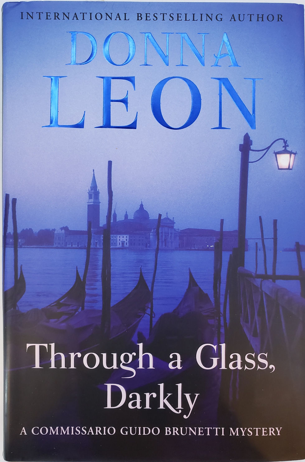 THROUGH A GLASS, DARKLY, a Commissario Guido Brunetti Mystery by Donna Leon