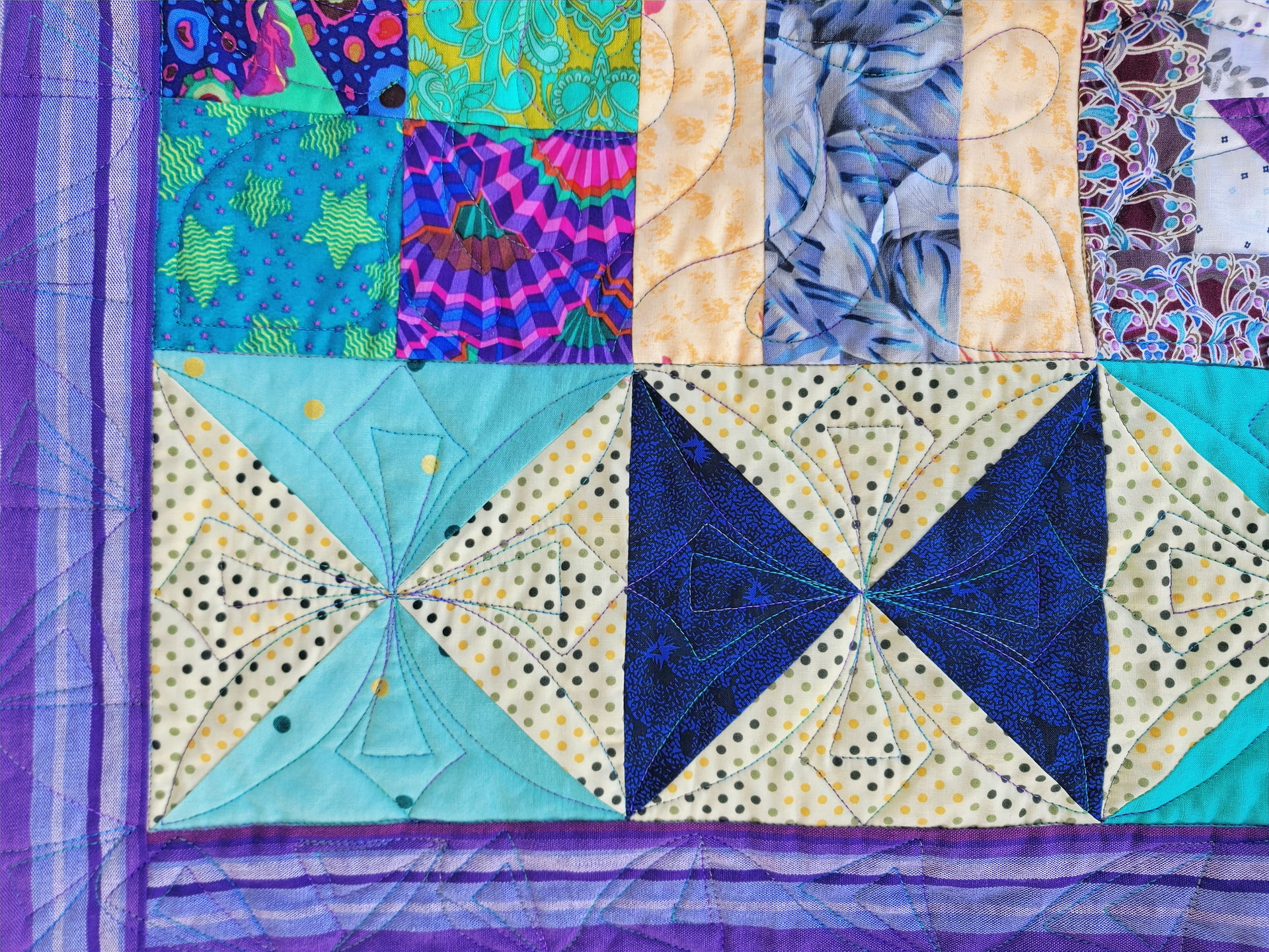 Custom quilting on a quilt panel with various patterns and colors