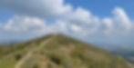 The Malvern Hills looking North, it's a sunny day and the sky is blue and there are lots of clouds.