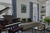 Luxury interior design featuring a grand piano, custom blue drapery, and built-in shelving by Thurman Design Studio in Nashville, TN.