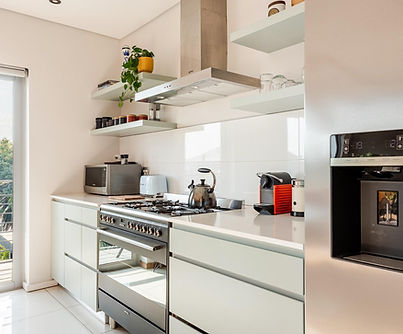 Modern kitchen with stainless steel appliances and balcony view