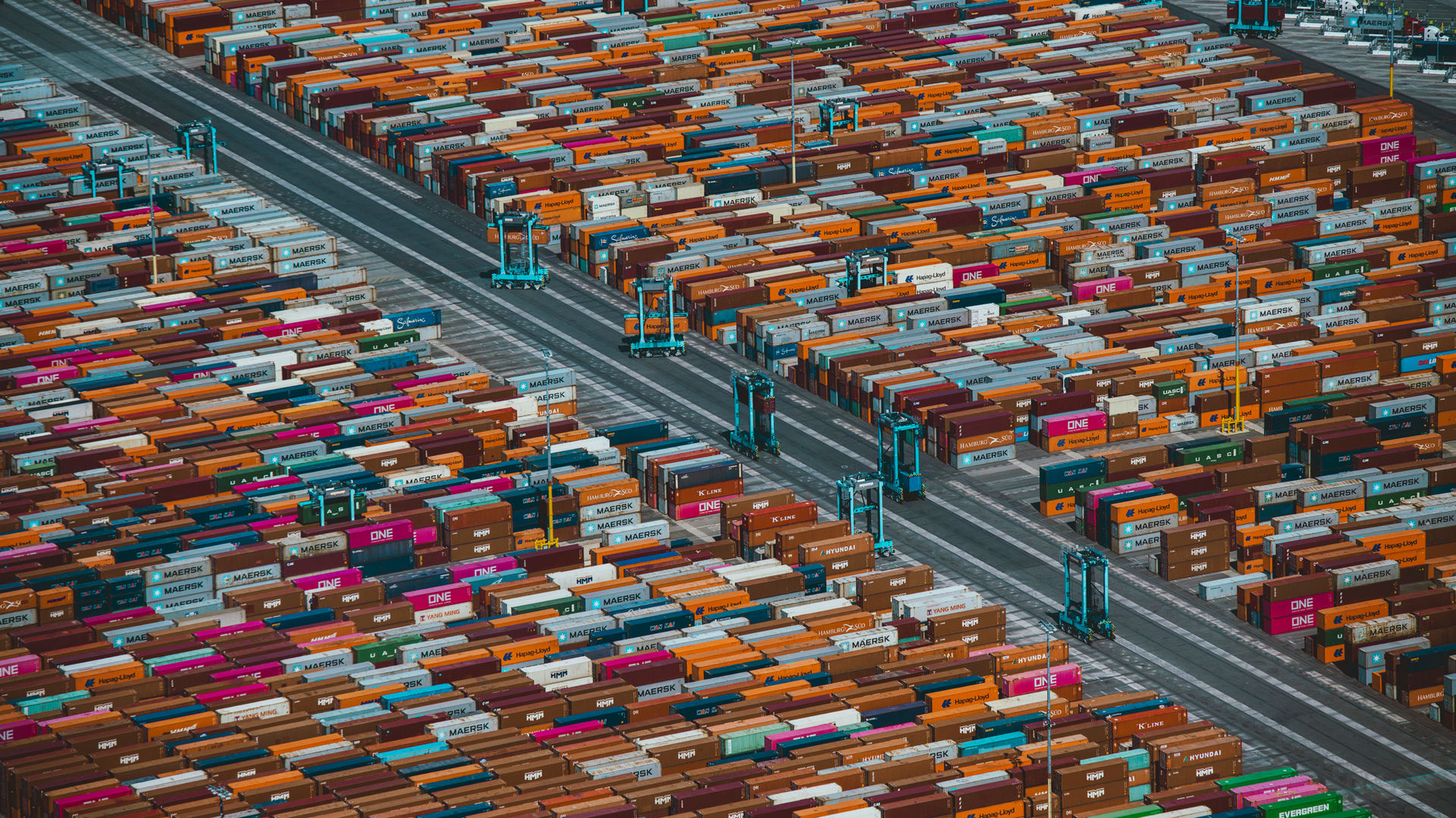 Overhead view of blue container mules moving thousands of colorful shipping containers at APM Terminal Pier 400 Los Angeles Harbor