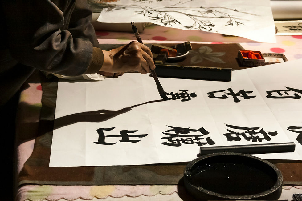A person writing Chinese characters on rice paper