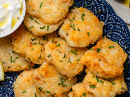 Golden Greek salt cod fritters (Bakaliaros) made with flaky salt cod and a crispy gluten-free batter, served with lemon and skordalia.