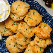 Platter of crispy gluten-free Greek salt cod fritters (Bakaliaro) with parsley, lemon and skordalia