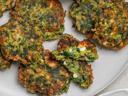Golden gluten-free spinach and feta fritters made with fresh herbs, served with lemon wedges and tzatziki.