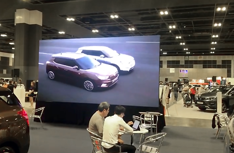 "Indoor LED Screen at Car Show for Event Hire" A sleek indoor LED screen displayed at a car show, ideal for event hire. The h