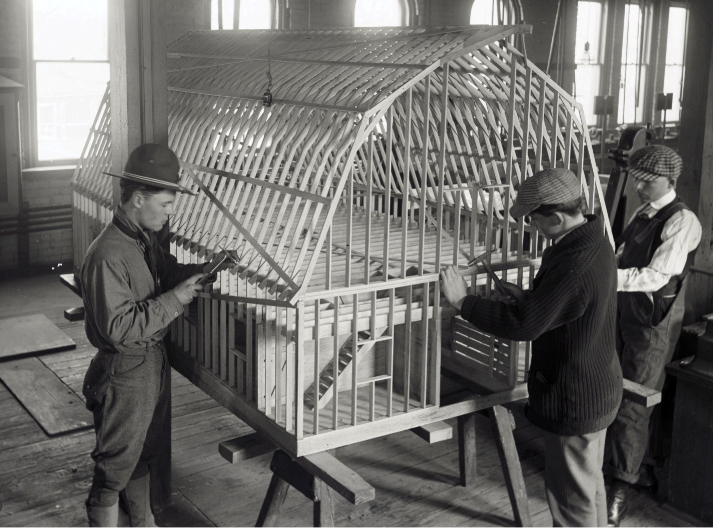 Historical black-and-white photograph of CSU students working on a wood-framed model in a classroom.