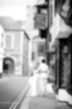 Wedding couple walking in a historic town street.