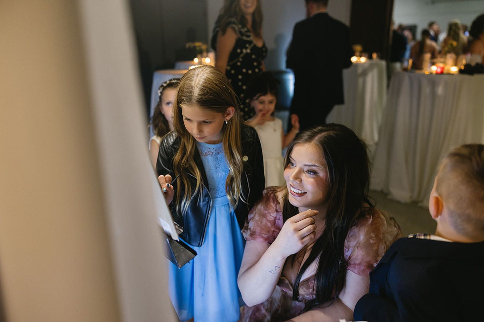 Kids helping with a painting during wedding celebration.
