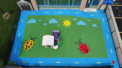 Rubber playground surface with ladybugs, clouds and sun