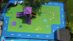 Green rubber playground surface with colourful stars and circles