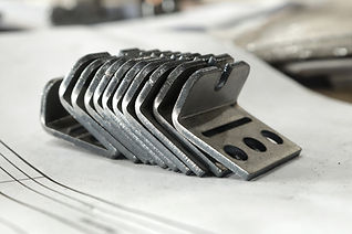 Metal products bent on a bending machine lie on a white background. Factory made products.