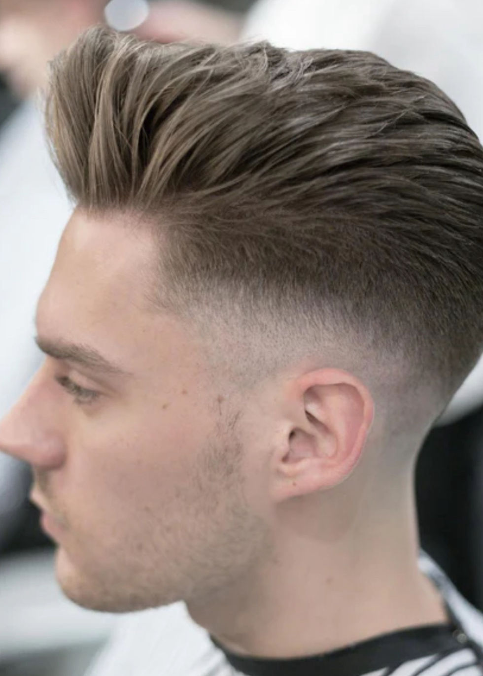 High angle view of a barber applying pomade to a client's hair