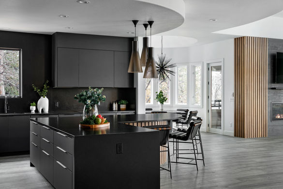 Full kitchen view with black cabinetry, sculptural pendant lights, and light oak open shelving
