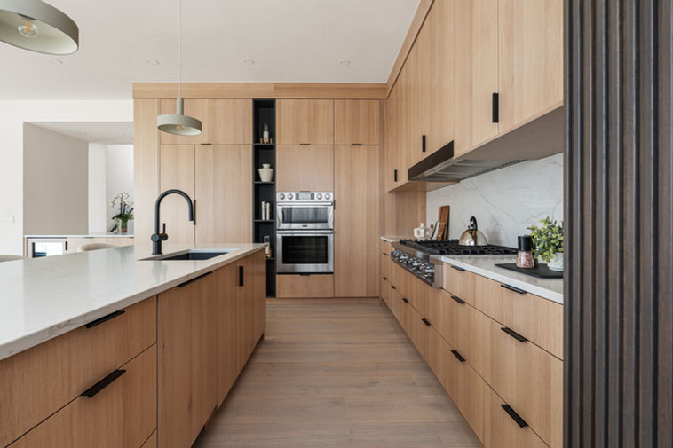 Chef’s kitchen with gas range, double ovens, quartz island, and integrated appliances at 2206 Alpine Drive.