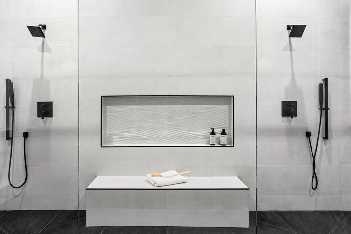 Double shower with built-in bench and a textured tile niche featuring wave-patterned wall tile
