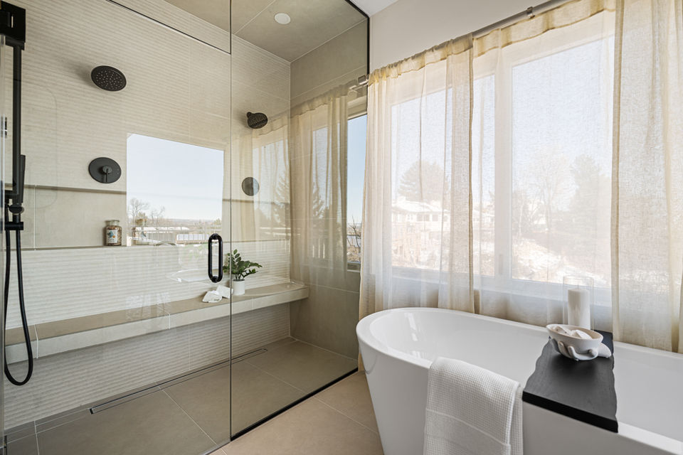 Walk-in shower with built-in bench, textured tiles, and matte black fixtures at 2206 Alpine Drive primary bathroom.