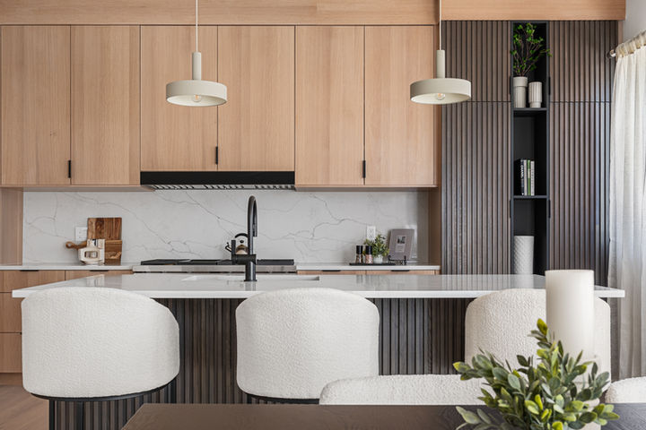 Kitchen island with slatted wood detail, pendant lighting, and modern oak cabinetry in 2206 Alpine Drive home.