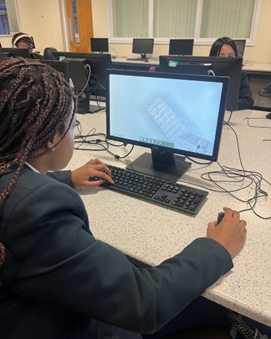 Student working on computer, photographed from behind.