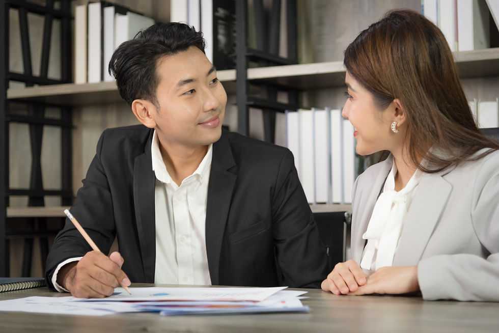 Asian financial consultant discussing loan options with a client in a professional office setting
