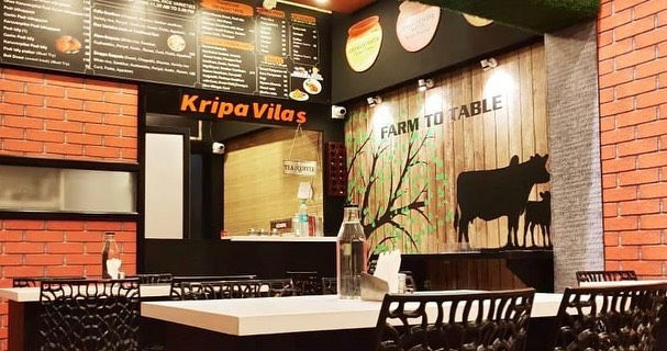 a restaurant with a menu on the wall and a cow on the wall .