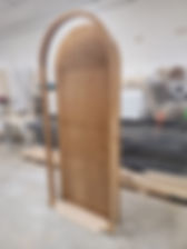 Custom exterior entry door made of natural wood with modern curved design
